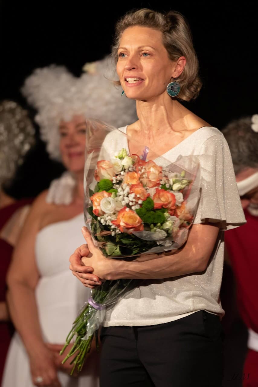 Virginie Morel (metteur en scène de l'association kff) avec un bouquet de fleurs dans les bras à la fin de la représentation de "Molière[s]"